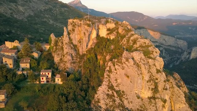 Aerial footage of a flyby of the historic mountain village Rougon in France during sunset