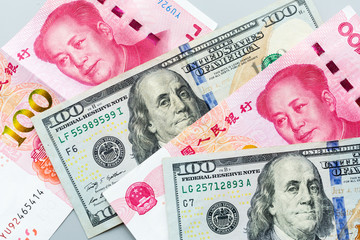 US dollar and Chinese yuan bank note. Trade war and conflict between two big countries. USA and...