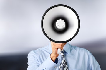 Young businessman talking on the megaphone on white background