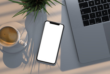 Smartphone blank screen next to laptop with coffee and grass flower