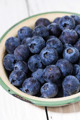 fresh juicy blueberries in a bowl, vertical closeup