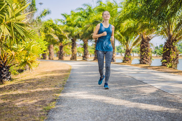 Fototapeta na wymiar Runner athlete running at tropical park. woman fitness sunrise jogging workout wellness concept