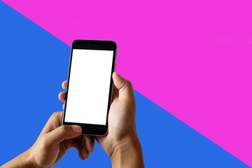 Hand holding white mobile phone with blank white screen in pallet color background.