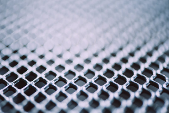Surface of latticed metal fence. Stainless steel and aluminum light blur background. Macro texture