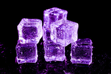 Purple ice cubes on a black table.