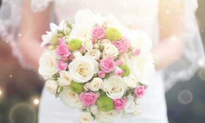 Bride with beautiful wedding bouquet on background