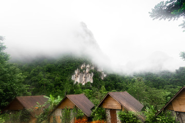 Beautiful Thailand Nature forest and mountain landscape with fog in the morning , House in the middle of the valley