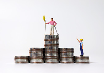 A graph-shaped pile of coins and a miniature person. The concept of economic stratification.