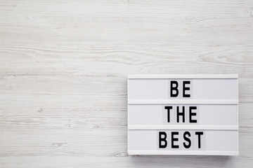 Modern board with 'Be the best' words on a white wooden surface. Flat lay, overhead, top view, from above. Copy space.