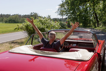 Senior Man in the red Ford Mustang Cabriolet