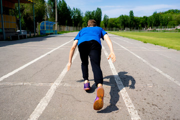 young runner athlete in the low start position on the sports track on stadium outdoor