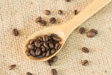 Coffee beans on woodspoon with sackcloth background