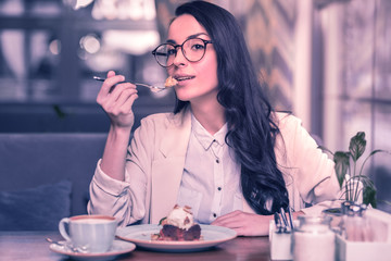 Pleasant attractive nice woman enjoying her cake