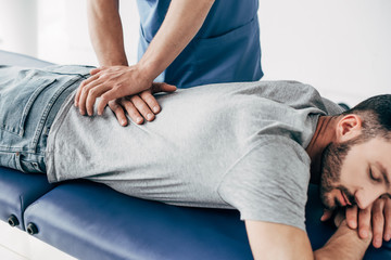 chiropractor massaging back of man on Massage Table in hospital - obrazy, fototapety, plakaty