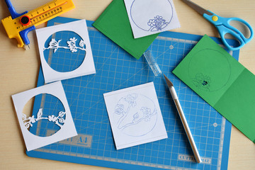 Making tunnelbook. 3D greeting card Spring. Artwork equipment and tools for paper cut - cutting knife, sharp box cutter, blue cutting plate, origami paper. Modern 3d origami paper art style.