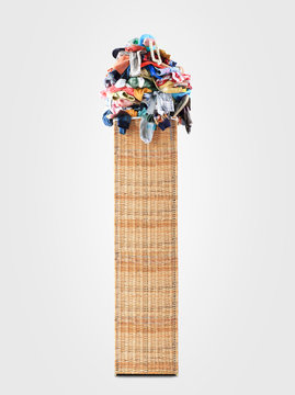 Beige straw basket full of dirty Laundry