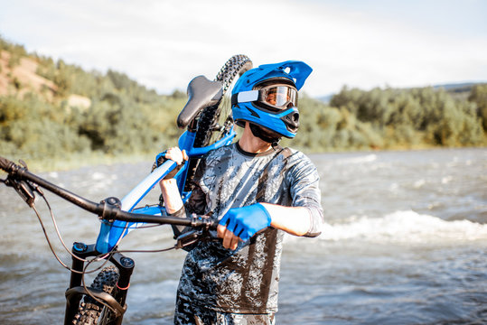 Professional Well-equipped Cyclist Standing With Bicycle On The Riverside In The Mountains. Concept Of A Freeride And Off Road Cycling