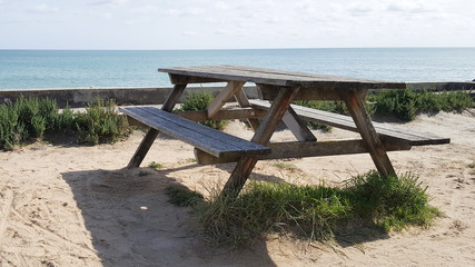 Fototapeta na wymiar wooden picnic table overlooking ocean sea beach