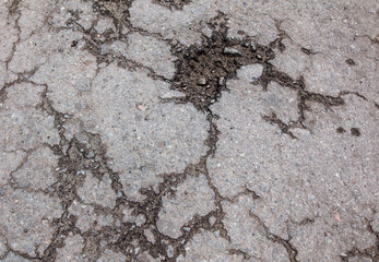 Cracks and pit on the asphalt road as background