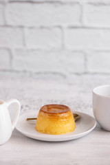 Creme caramel dessert or flan served with cup of coffee. Sweet moment vertical background.