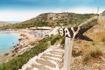 Bay caption on an old signpost. Stairs leading to sea resort town