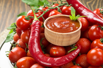 tomatoes lie on a silver plate of a bitter, tomatoes and chili peppers on them