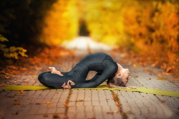 beautiful girl doing yoga in the fall