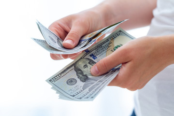 Person counts us dollars banknotes close up. Сurrency exchange and money distribution