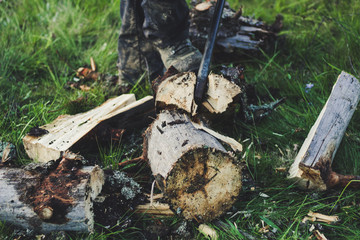 The guy is cutting an old tree in the mountains with an ax. Ukrainian Carpathian Mountains. Bonfire. Tourism. Ax