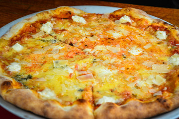 Four cheese pizza (Quattro Formaggio) on wooden table, Italian cuisine