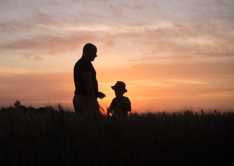 Fototapeta na wymiar father and son in the field in the evening
