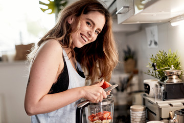 young caucasian brunette posing with a fresh strawberry.Posing  with a strawberry