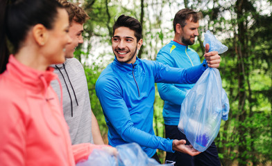 Group of fit people picking up litter in nature, a plogging concept.