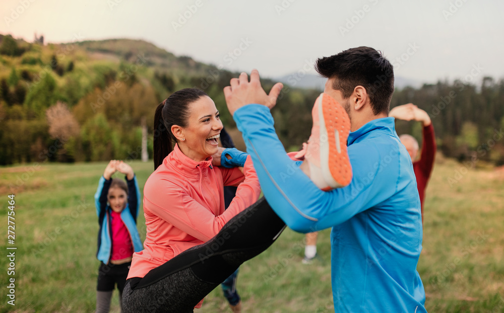 Sticker Large group of fit and active people doing exercise in nature.