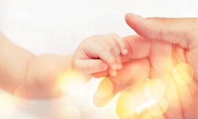 Close up photo of father holding baby hand