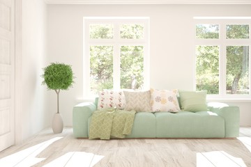 Fototapeta premium Stylish room in white color with sofa and summer landscape in window. Scandinavian interior design. 3D illustration