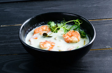 Vegetable cream soup with shrimps and croutons in white bowl close up