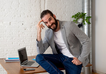 Portrait of attractive happy hipster businessman in modern fashion home office