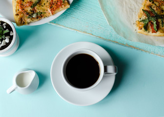 Coffee and Pizza. Beautiful flat lay with cup of coffee and pizza on blue background. Close up