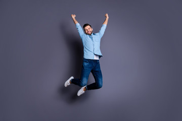 Full length body size view portrait of his he nice cool content cheerful cheery optimistic macho guy rising hands jumping up having fun isolated over gray violet purple pastel background