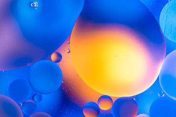 oily drops in water with colorful background, close-up 