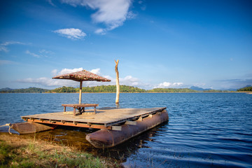 Beautiful wooden raft beside the lake behind the mountain view.