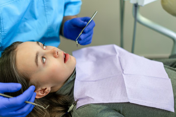 Dental clinic. Reception, examination of the patient. Teeth care. Young woman undergoes a dental examination by a dentist