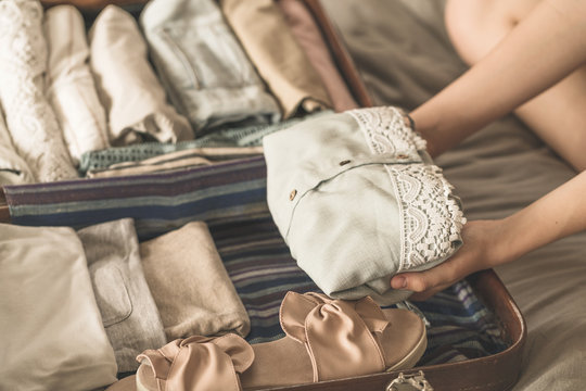 Summer Travel And Vacation Concept. Young Woman Packing Suitcase At Home