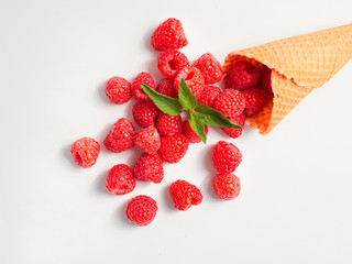 SUmmer raspberries with a mint leaf in waffle cone isolated on white background. Closeup top view
