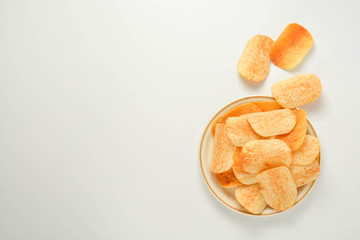 Potato chips in a plate isolated on a white background. Fast food snack.