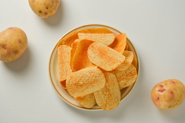 Potato chips in a plate isolated on a white background. Fast food snack.