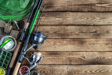 Fishing feeder and reel.Fishing tackle background.Fishing feeder- hooks and lures on darken wooden background.