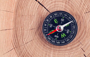 Fototapeta na wymiar compass on wood background concept for direction, travel, guidance or assistance