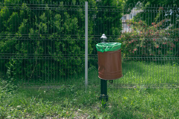 Damaged garbage bin inside public park. Environmental concept